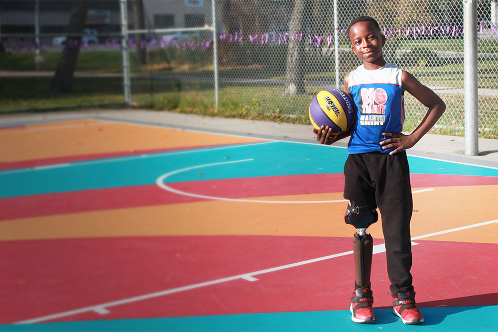 Jude smiling while holding basketball